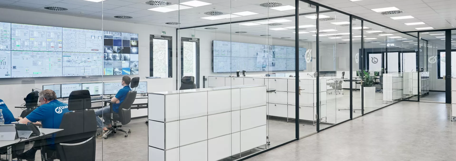 People in office in white and blue colours with screens