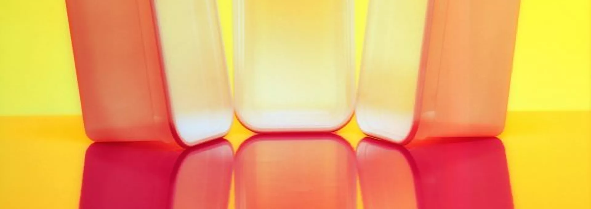 Photo of three tupperwares making a shadow with yellow background
