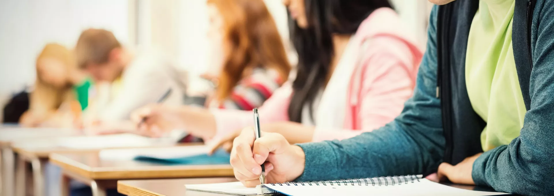 Young students writing notes in classroom
