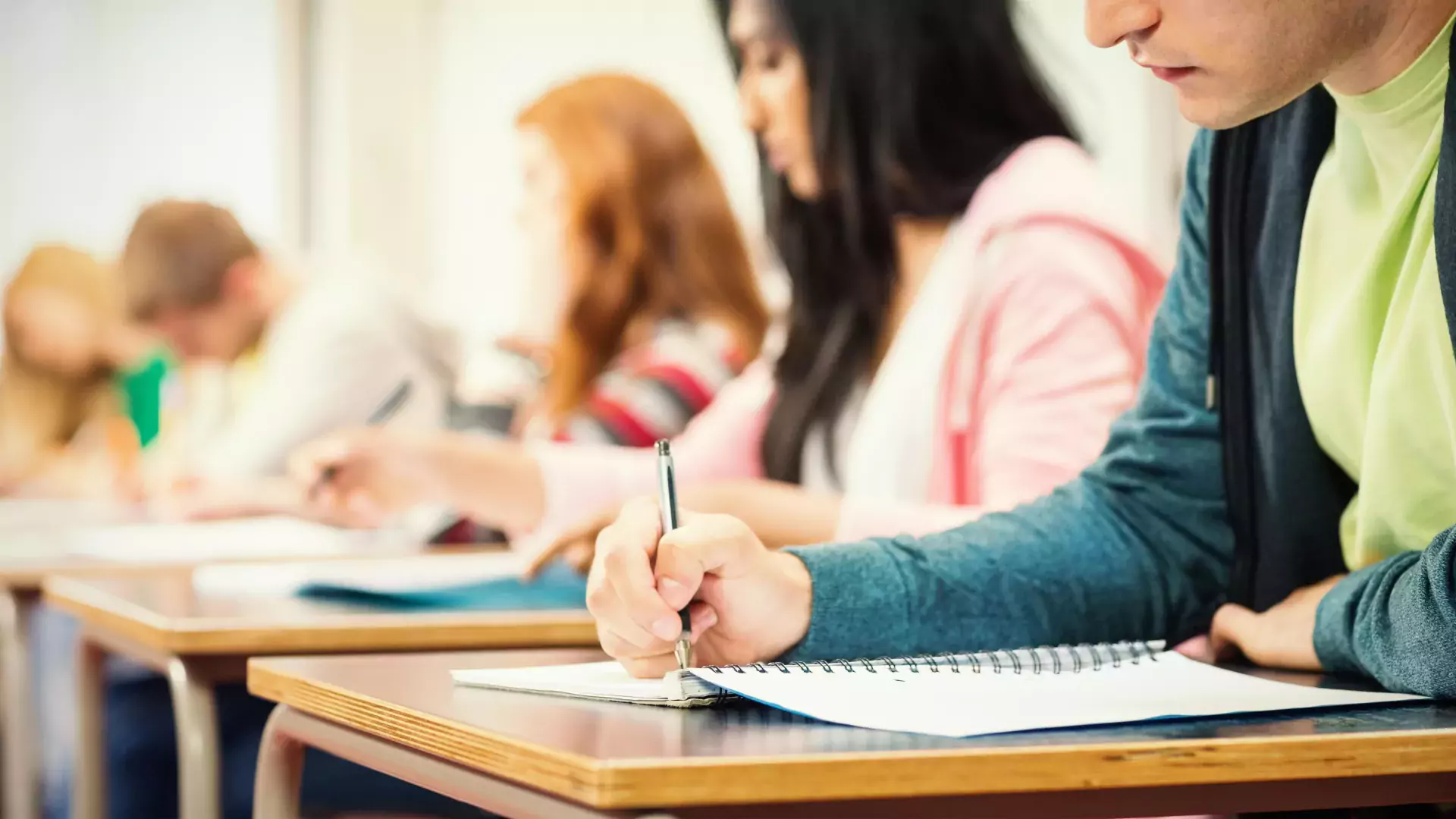 Young students writing notes in classroom