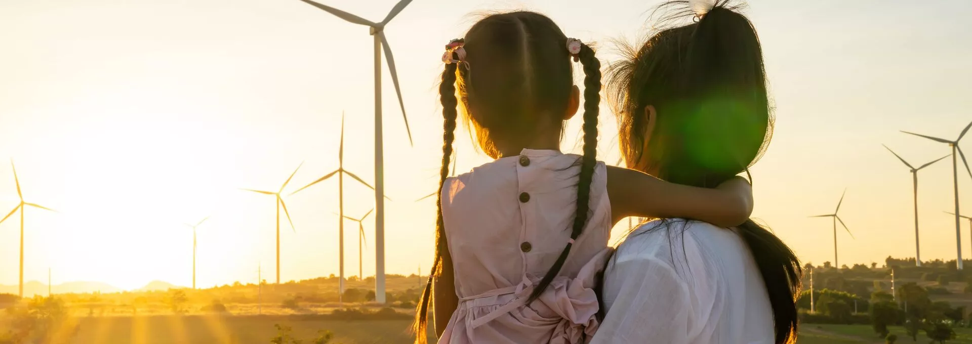 Woman looking away with her child with a sunset