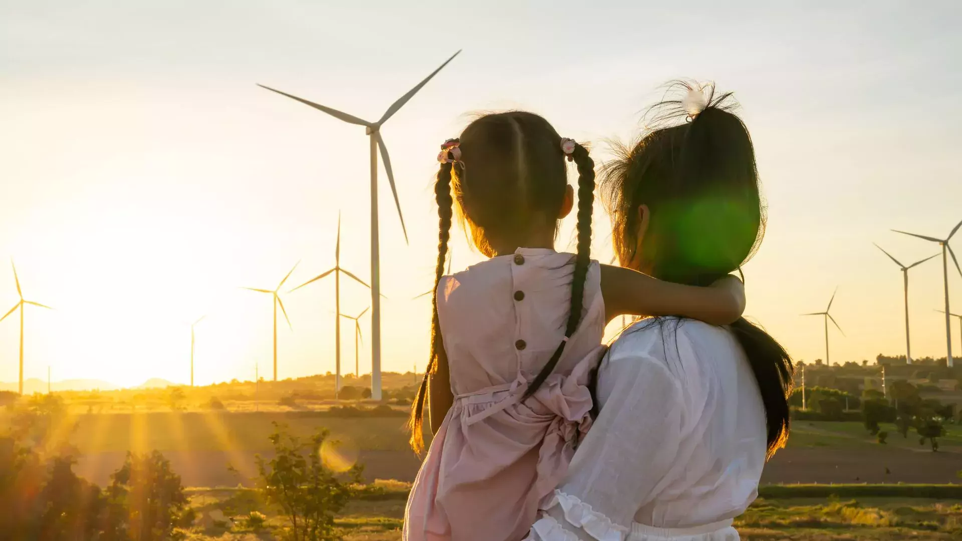 Woman looking away with her child with a sunset