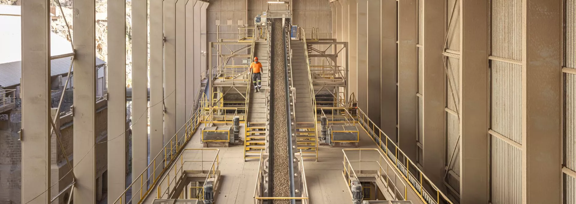 A worker coming down the steps in an industrial environment