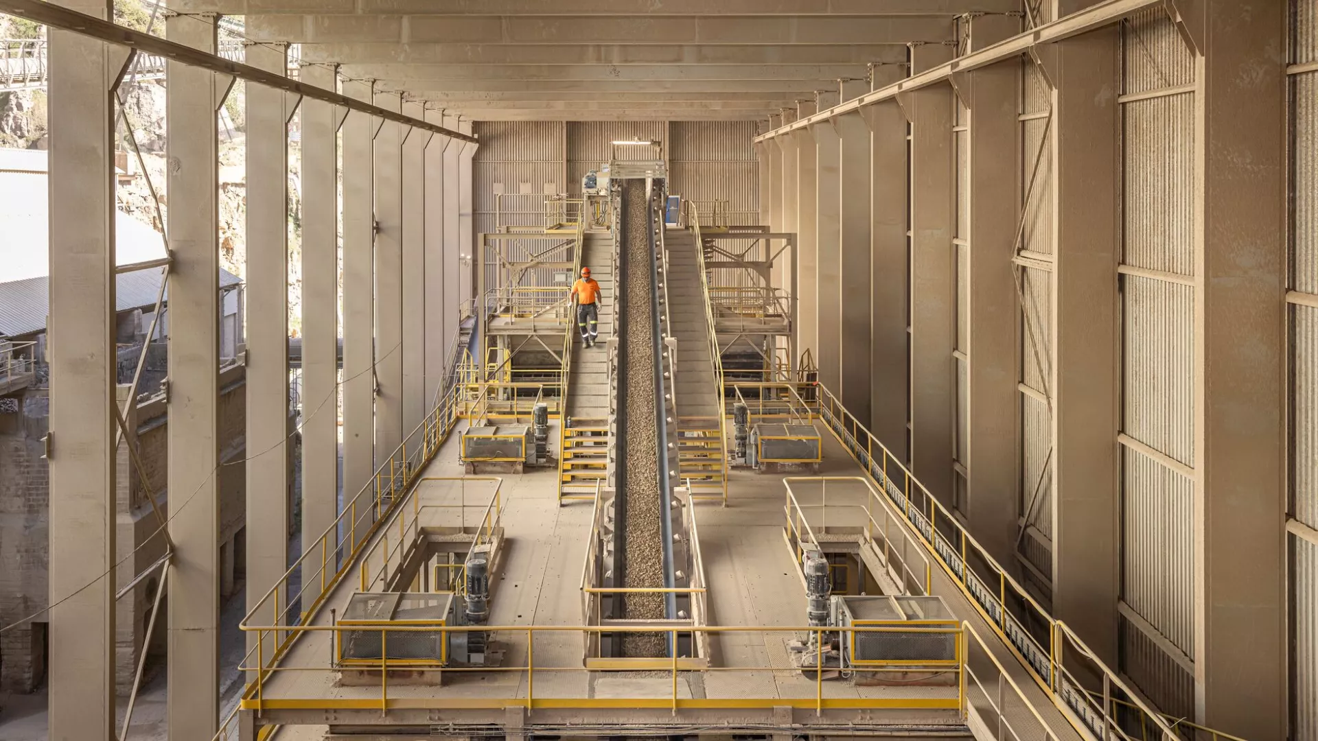 A worker coming down the steps in an industrial environment