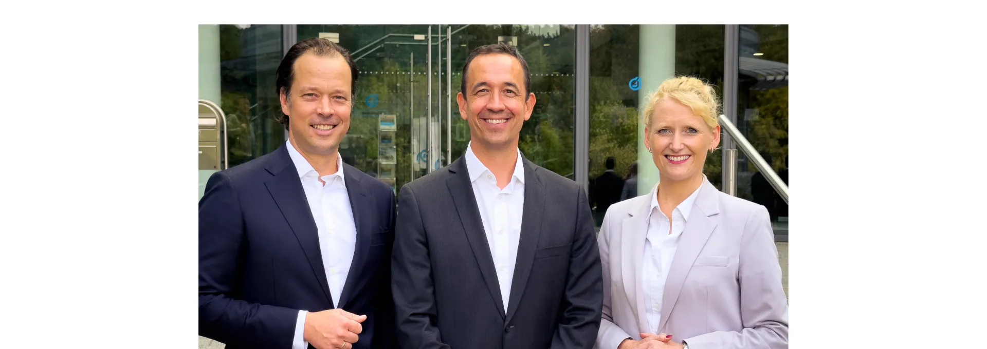 Three people in front of modern office building