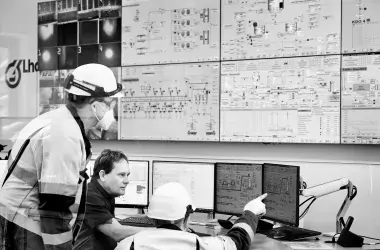 workers and employees looking at a wall of screens
