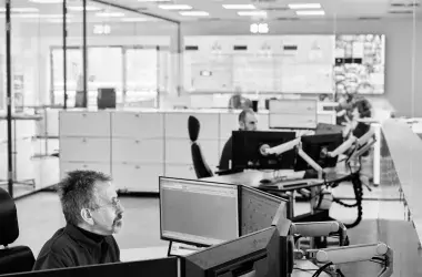 man sitting in front of computers and working on it