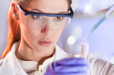 woman with protective glasses working in chemistry lab