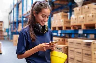 woman in warehouse with mobile phone