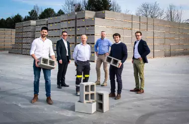 Several men standing with concrete blocks in the front and background