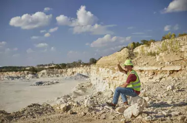 Portrait of an employee sit in a quarry looking at the horizon