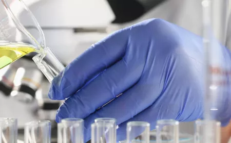 A male chemist holds test tube of glass in his hand
