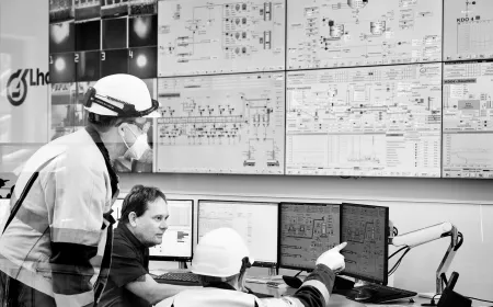 workers and employees looking at a wall of screens