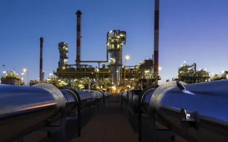 pipelines leading to an oil refinery at night and with lights