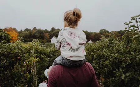 view from the back on adult with child on his shoulders