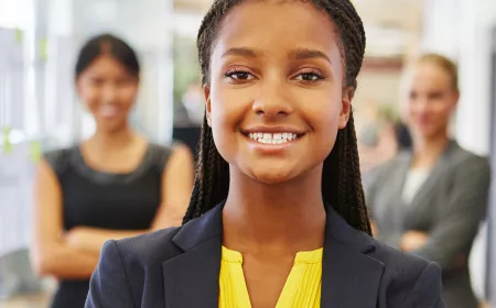 smiling young woman wearing yellow blouse and dark blue jacket