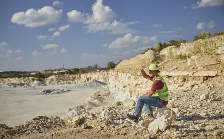 Portrait of an employee sit in a quarry looking at the horizon