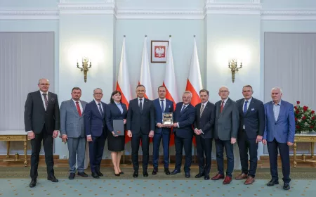 Group of people receiving an award in front of Polish flags