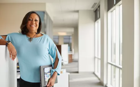 Woman in blue shirt standing in modern office environment