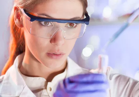 woman with protective glasses working in chemistry lab